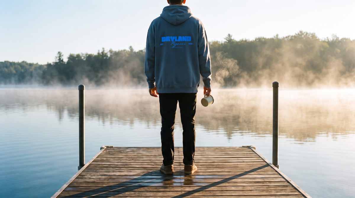 Model on a misty morning dock in the PIGOSKI Dryland Signature Fleece Hoodie — Hoodies and Sweats collection banner