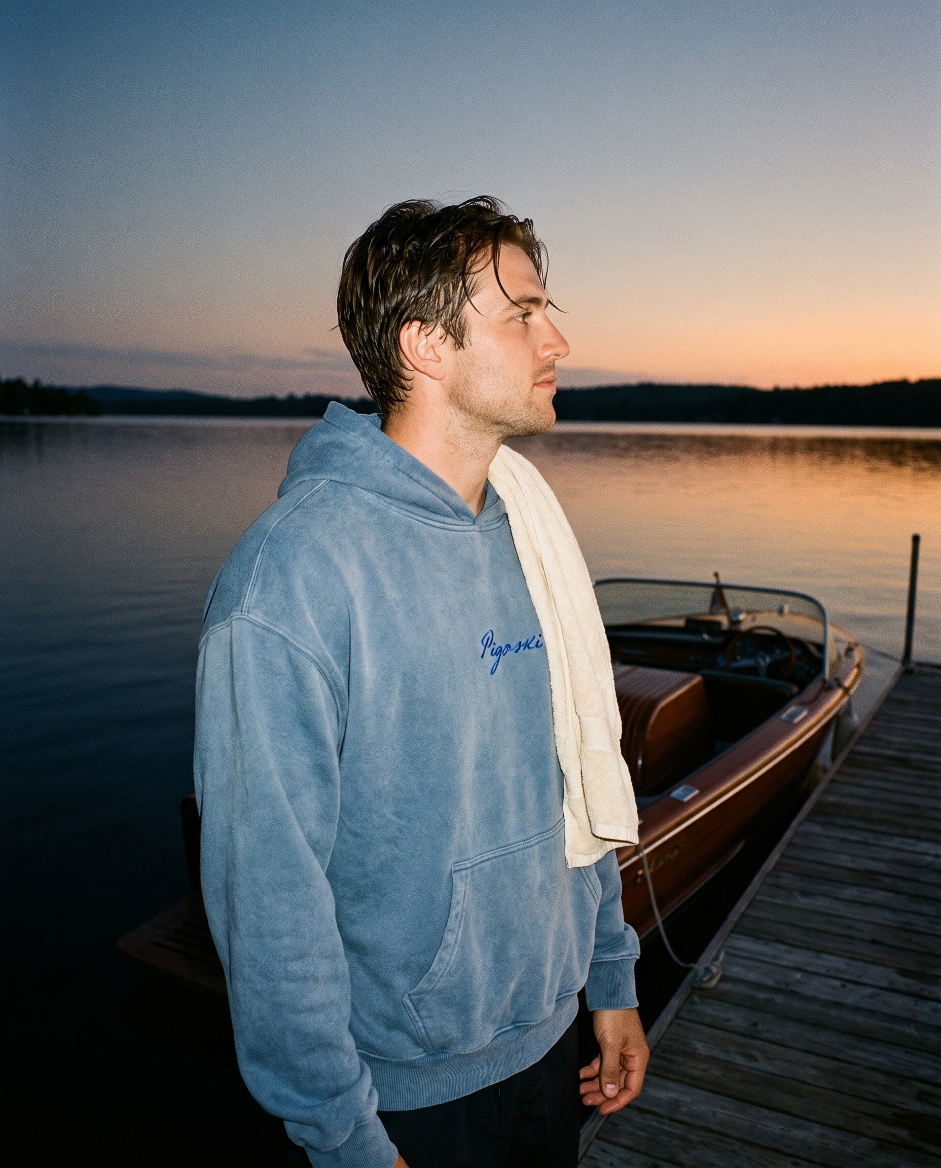 Skier in a washed-blue PIGOSKI fleece hoodie on the dock at dusk