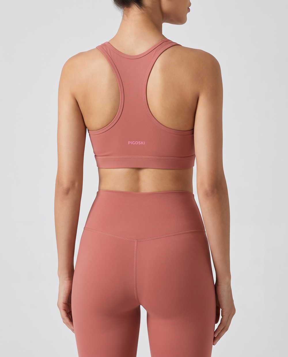 PIGOSKI Cropped Sports Bra — Women's on model — studio fit shot, back logo